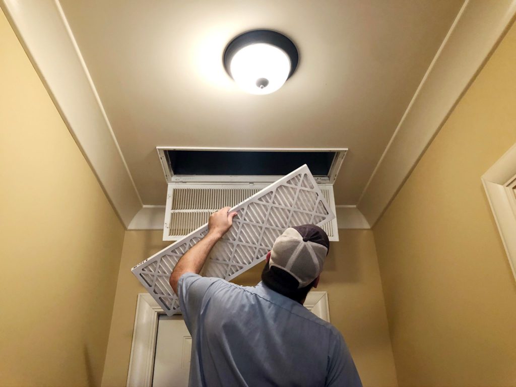 Environment Masters technician changing air filter in Jackson, MS, home.