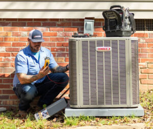 An Environment Masters technician performing a service on an outdoor AC unit.