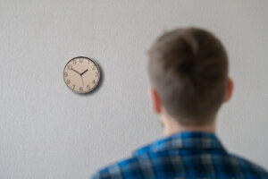 A man looking at a clock on a wall.